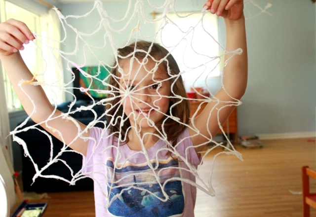 Maia holding yarn spiderweb